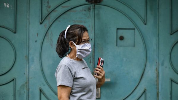 A women wearing a face mask, amid concerns of the COVID-19 coronavirus, walks on a street in Banda Aceh on April 7, 2020. CHAIDEER MAHYUDDIN / AFP