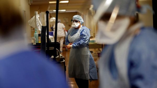 A nurse puts on protective gear prior to tending to a patient infected with COVID-19 at the intensive care unit of the Peupliers private hospital in Paris, on April 7, 2020, on the 22nd day of a strict lockdown in France aimed at curbing the spread of the COVID-19 pandemic, caused by the novel coronavirus. THOMAS COEX / AFP