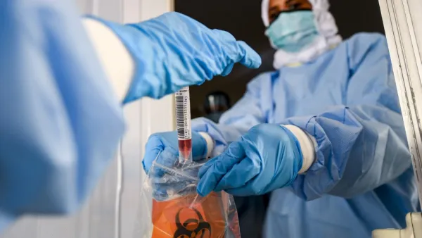 Laboratory workers bag a biological sample at a drive-through COVID-19 coronavirus testing centre in al-Khawaneej district of the gulf emirate of Dubai on April 9, 2020. KARIM SAHIB / AFP