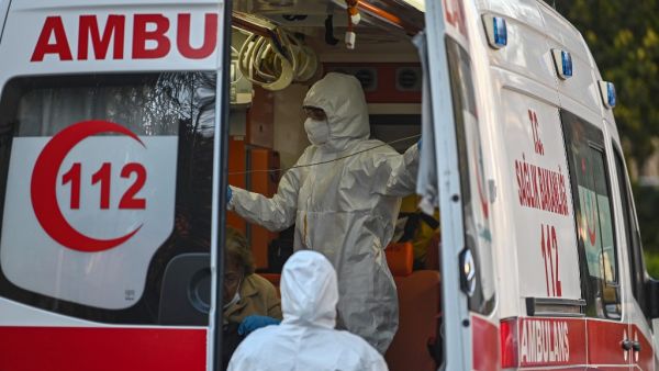 First aid workers wearing protectional equipment looks after a woman suspected of being infected with COVID-19, as she is evacuated by ambulance on April 12, 2020 in Istanbul, during a two-day curfew to prevent the spread of the epidemic COVID-19 caused by the novel coronavirus. Ozan KOSE / AFP