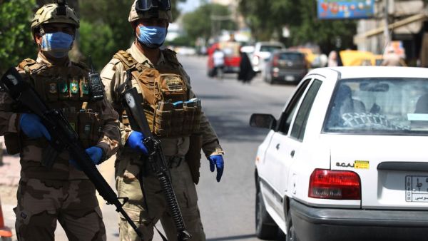 Iraqi soldiers stand at a checkpoint in the Adhamiya district of Baghdad on April 13, 2020 as Iraq imposed a curfew during the coronavirus COVID-19 pandemic. AHMAD AL-RUBAYE / AFP