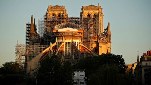 This picture taken on April 14, 2020 shows the Paris' Cathedral Notre Dame at the sunrise on the eve of the first anniversary of the violent fire who destroyed a large part of the monument, on the twenty-nineth day of a lockdown in France to stop the spread of the COVID-19, (the novel coronavirus). One year ago, on April 15, 2019, a fire erupted in Notre-Dame Cathedral in Paris, partly destroying the nearly millenium old building and its precious artworks visited by millions of people a year. THOMAS COEX / 