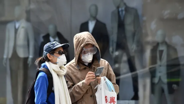 People wear face masks as they walk on a street on April 21, 2020 in front of closed stores in Munich, southern Germany, amid the new coronavirus COVID-19 pandemic. Christof STACHE / AFP