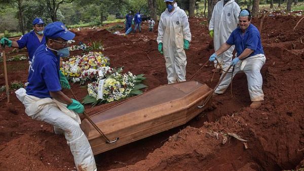 Employees bury a person who died from COVID-19 at the Vila Formosa cemetery, in the outskirts of Sao Paulo, Brazil. (AFP)