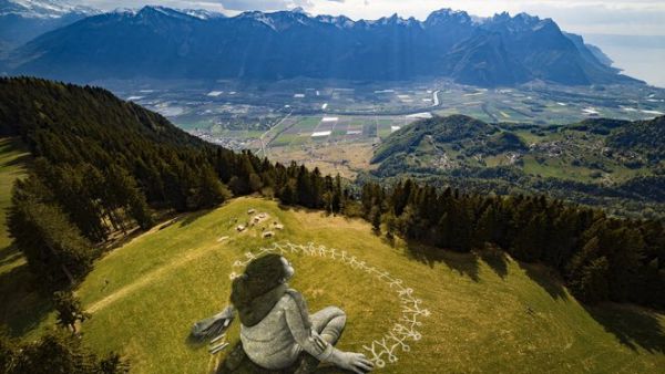 "Beyond crisis", his new work on a clearing in the Swiss resort town of Leysin, shows a girl sitting, completing a chain of stick figures holding hands.(Twitter)