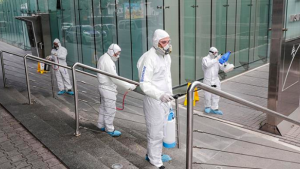 Employees of a private company spray sanitising liquid around a bank to limit the spread of the coronavirus in the Lebanese capital Beirut [Anwar Amro/AFP]
