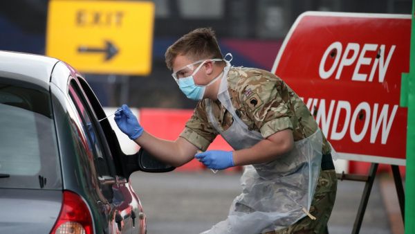 A soldier from 2 Scots Royal Regiment of Scotland tests a key worker for the novel coronavirus Covid-19 at a drive-in testing centre at Glasgow Airport on April 29, 2020, as the UK continues in lockdown to help curb the spread of the coronavirus. Andrew Milligan / POOL / AFP