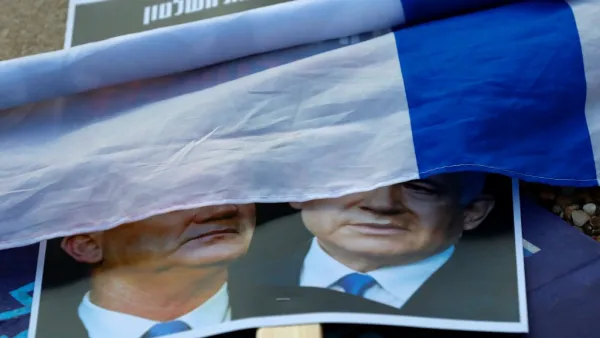 A rolled Israeli flag lies upon a placard left on the street with a picture of Prime Minister Benjamin Netanyahu and his rival-turned-partner Benny Gantz, during a demonstration in Tel Aviv's Rabin Square on May 2, 2020, in favour of the Supreme Court to consider tomorrow to block the coalition government agreed between the two men. If the expanded panel of 11 judges set to hear the case deems the coalition deal invalid, Israel may be forced to hold its fourth election in less than two years. JACK GUEZ / AF