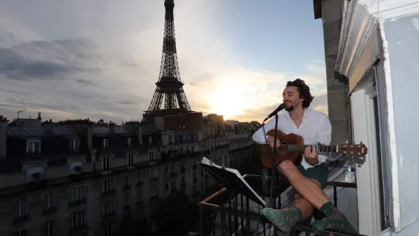 Singer Adrien Pelon aka "Adri1" performs from his balcony for his neighborhood on May 2, 2020, in Paris, as the country is under lockdown to stop the spread of the Covid-19 pandemic caused by the novel coronavirus. Ludovic MARIN / AFP