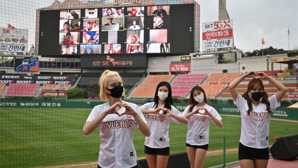 Cheerleaders pose in front of a big screen displaying baseball fans cheering from their homes during the opening game of South Korea's new baseball season between the SK Wyverns and Hanwha Eagles at Munhak Baseball Stadium in Incheon on May 5, 2020. South Korea's professional sport returned to action on May 5 after the coronavirus shutdown with the opening of a new baseball season, while football and golf will soon follow suit in a ray of hope for suspended competitions worldwide. Jung Yeon-je / AFP