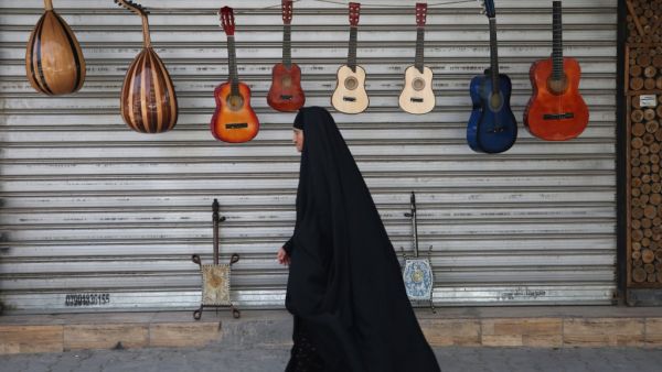 An Iraqi woman walks past musical instruments for sale in central Baghdad on May 5, 2020 during of the Muslim holy month of Ramadan after authorities eased up the lockdown measures that they had imposed in a bid to slow the spread of the novel coronavirus Covid-19. AHMAD AL-RUBAYE / AFP