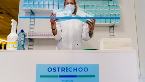 A woman poses with boxes of protective facemasks in pop-up facemask shop, in Rotterdam, on May 5, 2020. Marco DE SWART / ANP / AFP