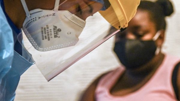 A health worker prepares to take a sample for a COVID-19 test at a patient's home in Medellin, Colombia on May 8, 2020. JOAQUIN SARMIENTO / AFP