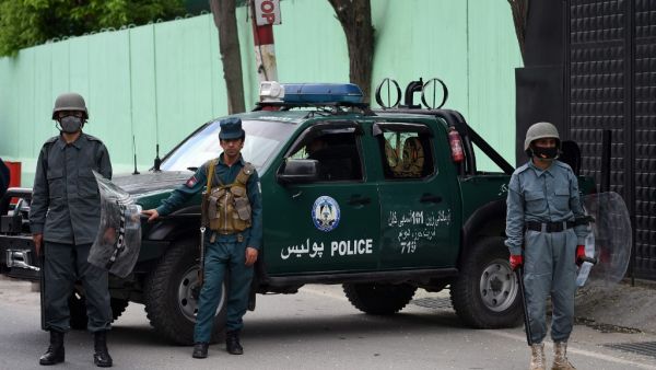 Afghan security personnel stand guard as civil society activists (not pictured) hold banners and shout slogans against the Iranian government during a protest in front of the Iranian embassy in Kabul on May 11, 2020. (AFP)