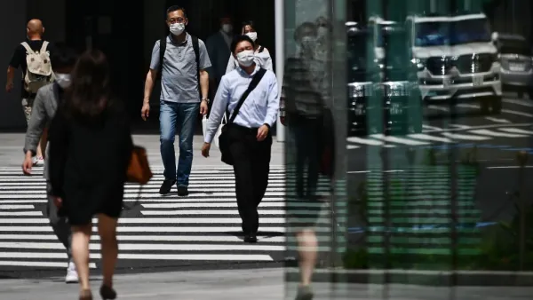 People wearing face masks amid the COVID-19 coronavirus outbreak walk across a street in Tokyo on May 13, 2020. Charly TRIBALLEAU / AFP