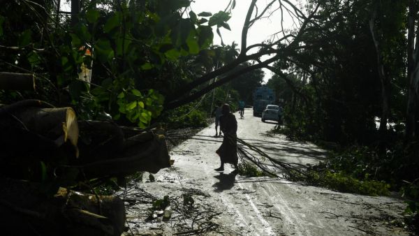 A woman removes debris from a road after the landfall of cyclone Amphan in Midnapore, West Bengal, on May 21, 2020. The strongest cyclone in decades slammed into Bangladesh and eastern India on May 20, sending water surging inland and leaving a trail of destruction as the death toll rose to at least nine. Dibyangshu SARKAR / AFP