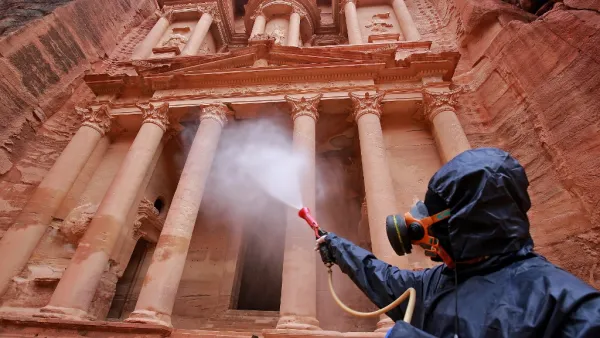 In this file photo taken on March 17, 2020, a labourer sprays disinfectant in Jordan's archaeological city of Petra south of the capital Amman on March 17, 2020, to prevent the spread of COVID-19.  (AFP/File)