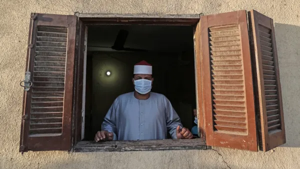 The Imam of a local mosque in the village of Shamma in Egypt's northern Nile delta province of Menoufia stands clad in mask due to the COVID-19 coronavirus pandemic by a window near the mosque early on May 24, 2020, before the prayers of Eid al-Fitr, the Muslim holiday which starts at the conclusion of the holy fasting month of Ramadan. (AFP/File Photo)