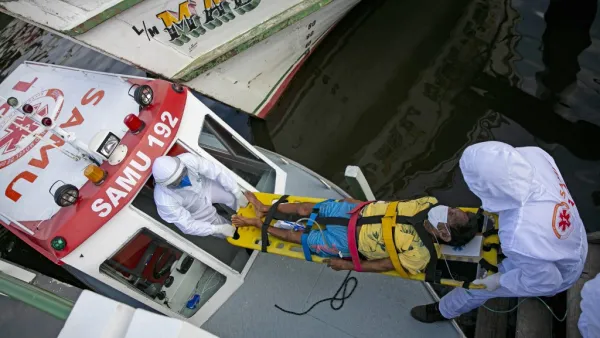 Health personnel of a medical emergency response service carry Brazilian Eladio Lopes, 79, -infected with the new coronavirus- on a stretcher to be transferred on an ambulance boat from the community of Portel to a hospital in Breves, on Marajo island, Para state, Brazil, on May 25, 2020. Ambulance boat services allow critical COVID-19 patients to be tranferred in very remote areas surrounded by water in Brazil. TARSO SARRAF / AFP