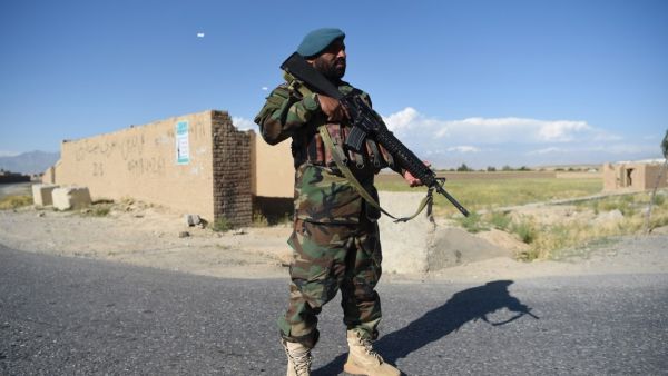 An Afghan National Army (ANA) soldier stands gourds as Taliban prisoners are released from the Bagram prison, at a checkpoint in the Bagram district of Afghanistan's Parwan Province on May 26, 2020. Afghan authorities plan to release 900 more Taliban prisoners on May 26, as calls grow for the militants to extend a ceasefire on its third and final day. WAKIL KOHSAR / AFP