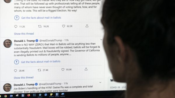 This illustration photo shows an editor in Los Angeles looking at the official Twitter account of US President Donald Trump on May 26, 2020, with two tweets by the president under which Twitter posted a link reading "Get the facts about mail-in ballots". Twitter labelled two of Donald Trump's tweets misleading on May 26, a first for the social media network which has long resisted calls to censure the US President over his frequent abuse, insults and false claims. Trump's tweets contended without evidence t