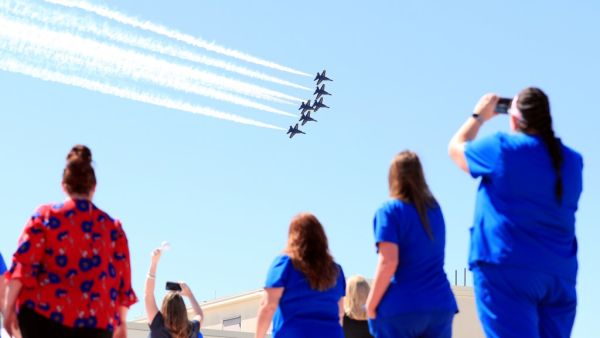 Hospital staff, including nurses, doctors and administrators, look on as the United States Navy Blue Angels pass over Medical City Dallas on May 06, 2020 in Dallas, Texas. (AFP)