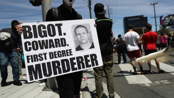 A protestor holds a sign with a photo of former Minneapolis police officer Derek Chauvin during demonstrations following the death of George Floyd on May 30, 2020 in Los Angeles, California. Chauvin was taken into custody for Floyd's death. (MARIO TAMA / GETTY IMAGES NORTH AMERICA / Getty Images via AFP)