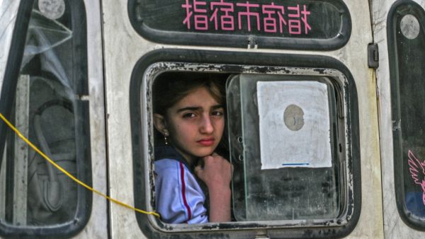 A girl looks from out the window of a vehicle leaving the town of Sarmin in Syria's northwestern Idib province, headed towards the border with Turkey, on March 10, 2020. Ozan KOSE / AFP