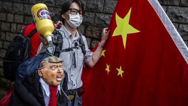 A pro-China activist holds an effigy of US President Donald Trump during a protest outside the US consulate in Hong Kong on May 30, 2020, in response to US President Donald Trump saying on May 29 he would strip several of Hong Kong's special privileges with the United States and bar some Chinese students from US universities in anger over Beijing's bid to exert control in the financial hub. ISAAC LAWRENCE / AFP