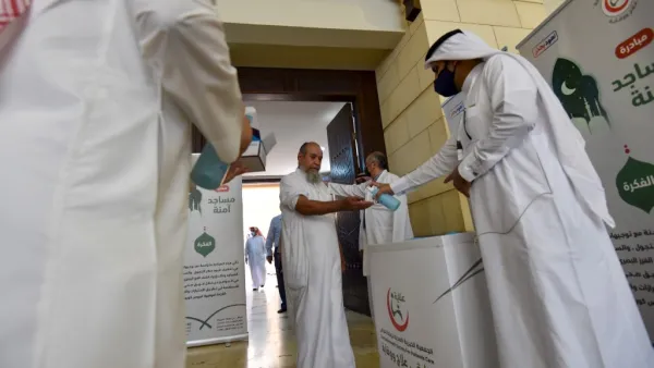 A Saudi medical worker sanitises the hands of a worshipper upon his arrival to perform noon prayer at Al-Rajhi mosque in the capital Riyadh on May 31 ,2020, after authorities eased lockdown measures for prayers in mosques. FAYEZ NURELDINE / AFP