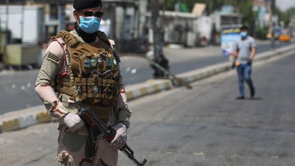 A member of the Iraqi security forces stands guard at a checkpoint, enforcing a curfew due to the COVID-19 coronavirus pandemic, in Baghdad's eastern Sadr City suburb on May 31, 2020. The Iraqi authorities imposed a week-long curfew to curb the latest increase in infections of coronavirus in the country. AHMAD AL-RUBAYE / AFP
