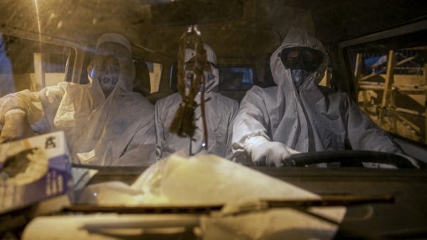 Gravediggers wearing protective clothing arrive in a funeral home's car at the Recanto da Paz Municipal Cemetery to bury a victim of the novel coronavirus COVID-19, in the city of Breves, southwest of Marajo Island, an island at the mouth of the Amazon River in the Brazilian state of Para, on May 30, 2020. The pandemic is spreading across Brazil under a cloud of confrontation, as governors and mayors implement restrictive measures while President Jair Bolsonaro, who has pinned his hopes of re-election on a 