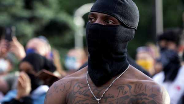 A demonstrator wearing a face mask is seen in Denver, Colorado on May 31, 2020, while protesting the death of George Floyd, an unarmed black man who died while while being arrested and pinned to the ground by the knee of a Minneapolis police officer. Thousands of National Guard troops patrolled major US cities after five consecutive nights of protests over racism and police brutality that boiled over into arson and looting, sending shock waves through the country. The death Monday of an unarmed black man, G