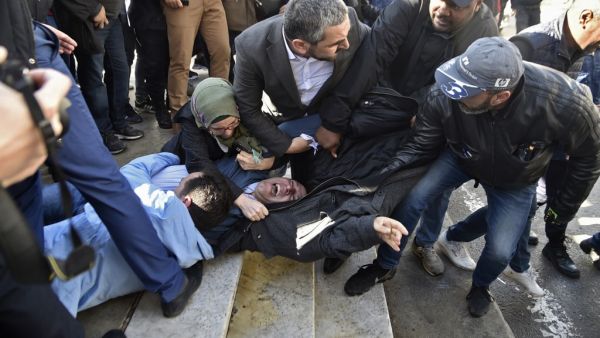 In this file photo taken on February 28, 2019, Samir Benlarbi (C), an Algerian opposition figure of the "Hirak" movement, tries to stop plain clothes policemen from detaining a protester participating in a rally organised by journalists against alleged censorship of coverage of protests against a fifth term for veteran President Abdelaziz Bouteflika in Algiers. Karim Tabbou and Samir Benlarbi, two of the main figures of Algeria's "Hirak" protest movement, will soon be freed under presidential pardons, said 