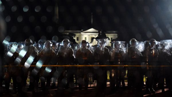 Police officers hold a perimeter behind the metal fence recently erected in front of the White House demonstrators gather to protest the killing of George Floyd on June 2, 2020 in Washington, DC. Anti-racism protests have put several US cities under curfew to suppress rioting, following the death of George Floyd in police custody. Olivier DOULIERY / AFP