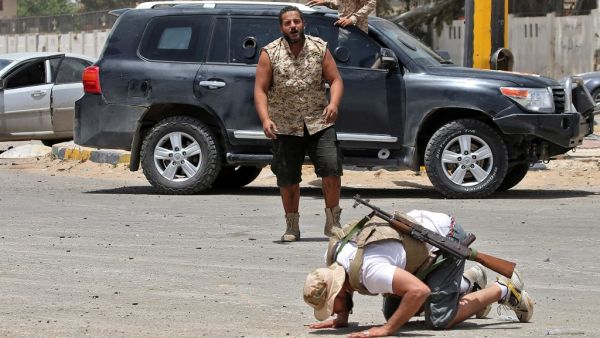 A fighter loyal to the UN-recognised Libyan Government of National Accord (GNA) prostrates in prayer as an expression of gratitude as his comrades celebrate in the Qasr bin Ghashir district south of the Libyan capital Tripoli on June 4, 2020, after the area was taken over by pro-GNA forces following clashes with rival forces loyal to strongman Khalifa Haftar. The GNA said on June 4 that it was back in full control of the capital and its suburbs after more than a year of fighting off an offensive by eastern 