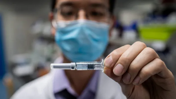 This file photo taken on April 29, 2020 shows an engineer displaying an experimental vaccine for the COVID-19 coronavirus that was tested at the Quality Control Laboratory at the Sinovac Biotech facilities in Beijing. China has mobilised its army and fast-tracked tests in the global race to find a coronavirus vaccine, and is involved in several of the dozen or so international clinical trials currently under way. NICOLAS ASFOURI / AFP