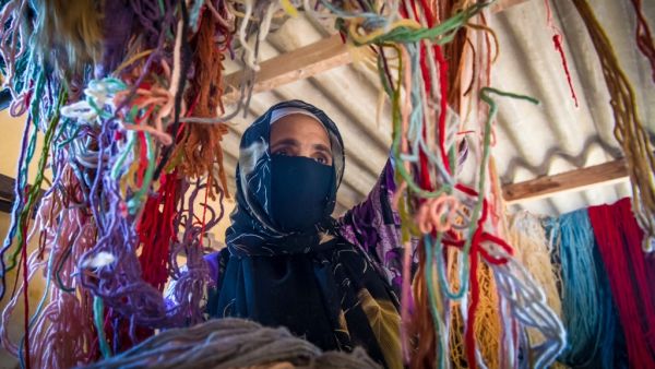 A Moroccan rug weaver sorts out yarn at a workshop in the city of Sale, north of the capital Rabat, on June 3, 2020, during the novel coronavirus pandemic. Artisans in Morocco have been starved of income for almost three months because of the COVID-19 pandemic. The crafts industry represents some seven percent of GDP, with an export turnover last year of nearly 1 billion dirhams ($100 million). FADEL SENNA / AFP