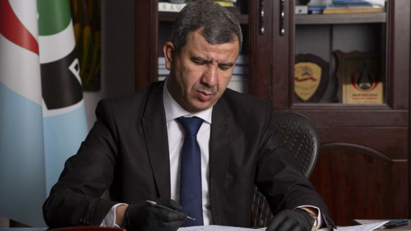 Newly-appointed Iraqi Minister of Oil Ihsan Ismaeel reads documents at the Basra Oil Company in Iraq's southern port city, on May 9, 2020. Hussein FALEH / AFP
