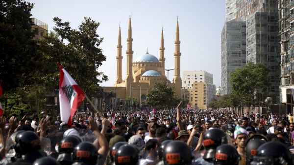 Lebanese riot police stand guard in front of protesters during a demonstration in central Beirut, on June 6, 2020. Protesters poured into the streets of the Lebanese capital to decry the collapse of the economy, as clashes erupted between supporters and opponents of the Iran-backed Shiite group Hezbollah. PATRICK BAZ / AFP