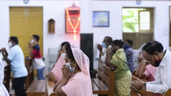 Catholic devotees wear face mask attend the Holy Mass at the Saint Joseph's Church on the first day after the reopening of religious services after the government eased restrictions imposed as a preventive measure against the COVID-19 coronavirus, in Hyderabad on June 8, 2020. NOAH SEELAM / AFP