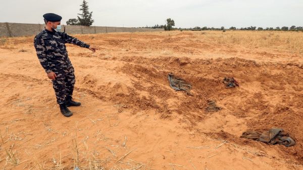 A member of security forces affiliated with the Libyan Government of National Accord (GNA)'s Interior Ministry points at the reported site of a mass grave in the town of Tarhuna, about 65 kilometres southeast of the capital Tripoli on June 11, 2020. Mahmud TURKIA / AFP