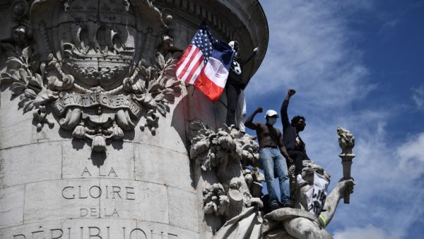 Protesters raise their fist from the statue of Marianne on Place de la Republique in Paris on June 13, 2020, during a rally as part of the 'Black Lives Matter' worldwide protests against racism and police brutality. Anne-Christine POUJOULAT / AFP