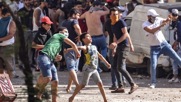 Lebanese anti-government protesters hurl rocks at soldiers amid clashes in the Bab al-Tabbaneh neighbourhood in the northern port city of Tripoli, on June 13, 2020, on the third consecutive day of angry demonstrations across the country due to a deepening economic crisis. The stand-off began after young men blocked a high way to prevent a number of trucks carrying produce destined to Syria from passing through, according to the official National News Agency, and the Lebanese Red Cross said it treated 9 peop
