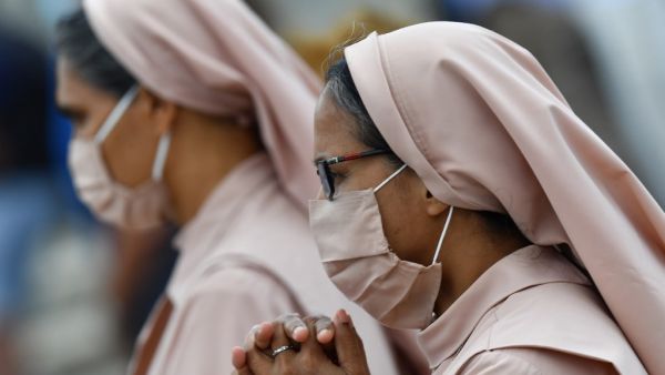 Nuns wearing a face mask attend the Pope's weekly Angelus prayer on June 14, 2020 at St. Peter's Square in The Vatican, as the city-state eases its lockdown aimed at curbing the spread of the COVID-19 infection, caused by the novel coronavirus. Tiziana FABI / AFP