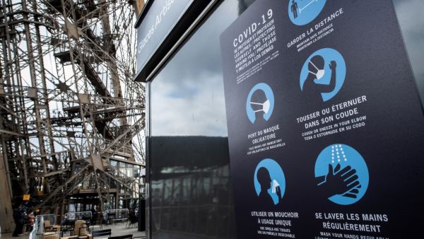 Sanitary instructions are seen on the waiting line to the Eiffel Tower, on June 15, 2020 in Paris, ahead of the partial reopening of the monument to the public as France eases lockdown measures taken to curb the spread of the Covid-19 pandemic (novel coronavirus). BERTRAND GUAY / AFP