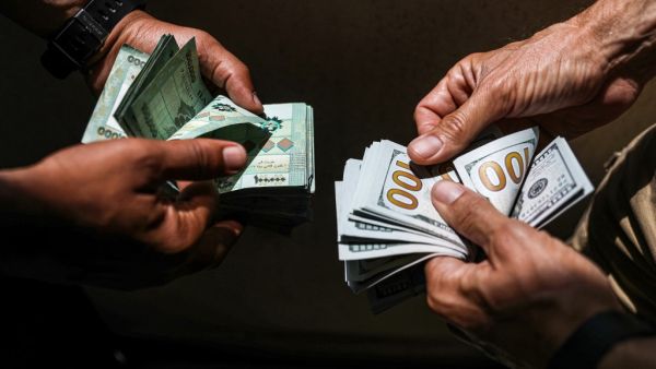 People exchange Lebanese pound and US dollar notes on the black market in Lebanon's capital Beirut on June 18, 2020. JOSEPH EID / AFP