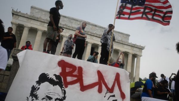 A man waves an American flag with the words "Not Free" painted on it as he takes part in a Juneteenth march and rally in front of the Lincoln Memorial in Washington, DC, on June 19, 2020. ANDREW CABALLERO-REYNOLDS / AFP