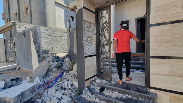 A libyan youth checks a damaged building entrance in the Salaheddin district south of the capital Tripoli, on June 21, 2020, as some residents return to the area after it has been demined. Since 2015, a power struggle has pitted the Tripoli-based Government of National Accord (GNA) against strongman Khalifa Haftar. (Mahmud TURKIA / AFP)