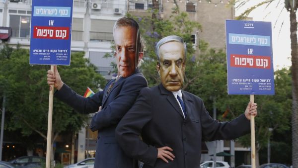 Protesters, wearing masks of Israel's Prime Minister Benjamin Netanyahu and his coalition partner Defence Minister Benny Gantz, take part in a demonstration in Tel Aviv's Rabin Square to denounce Israel's plan to annex parts of the occupied West Bank, on June 23, 2020. Only a week before Netanyahu intends to kick-start annexation plans in the occupied West Bank, Israel's premier is facing challenges at home and abroad. JACK GUEZ / AFP